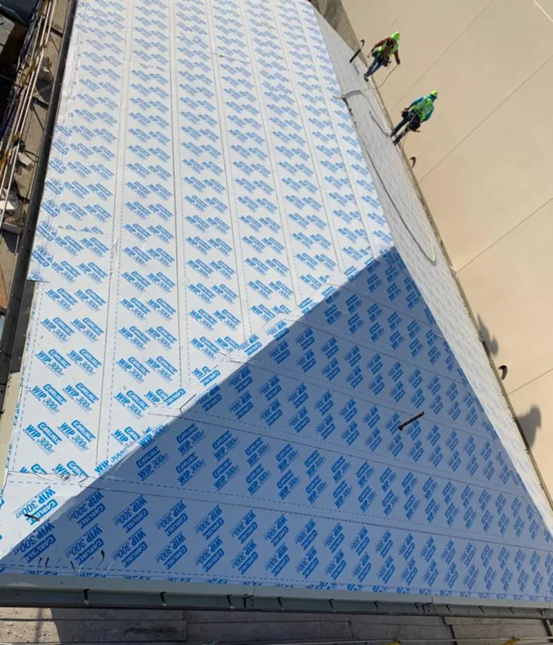 Professional roofers installing underlayment on a metal roof in Jackson